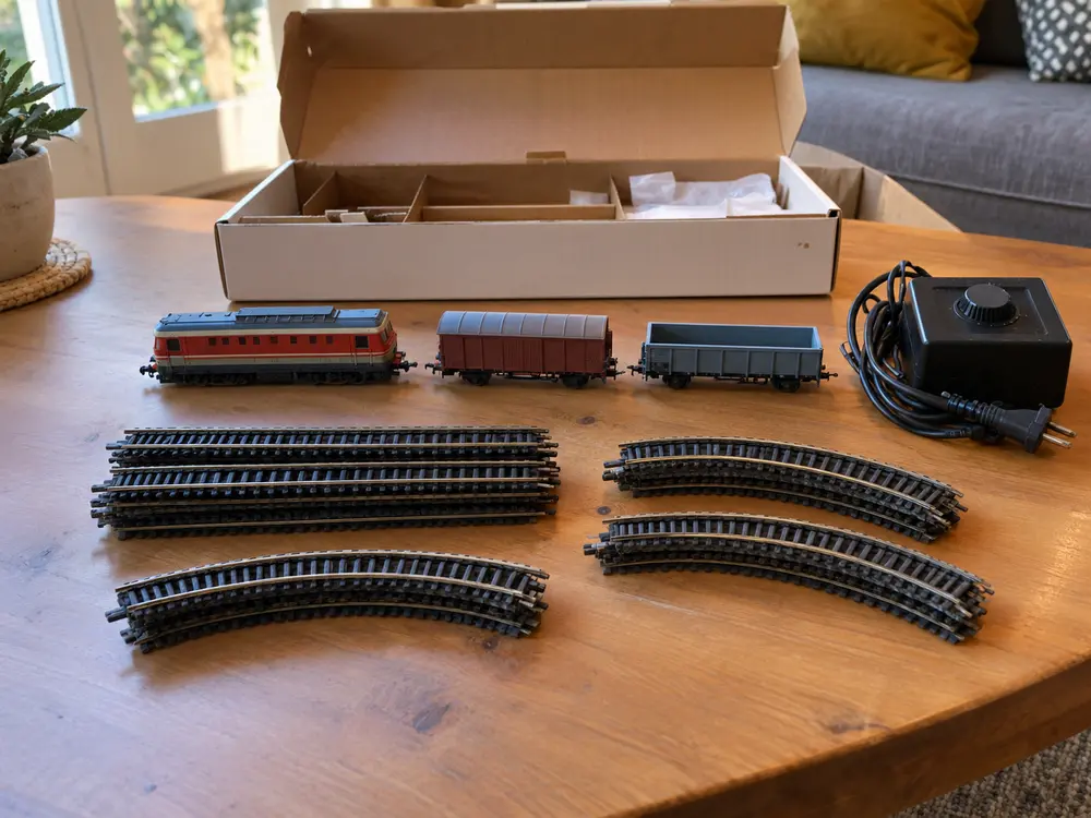 Contenu d’un coffret de départ en HO : locomotive, wagons, rails droits et courbes, transformateur