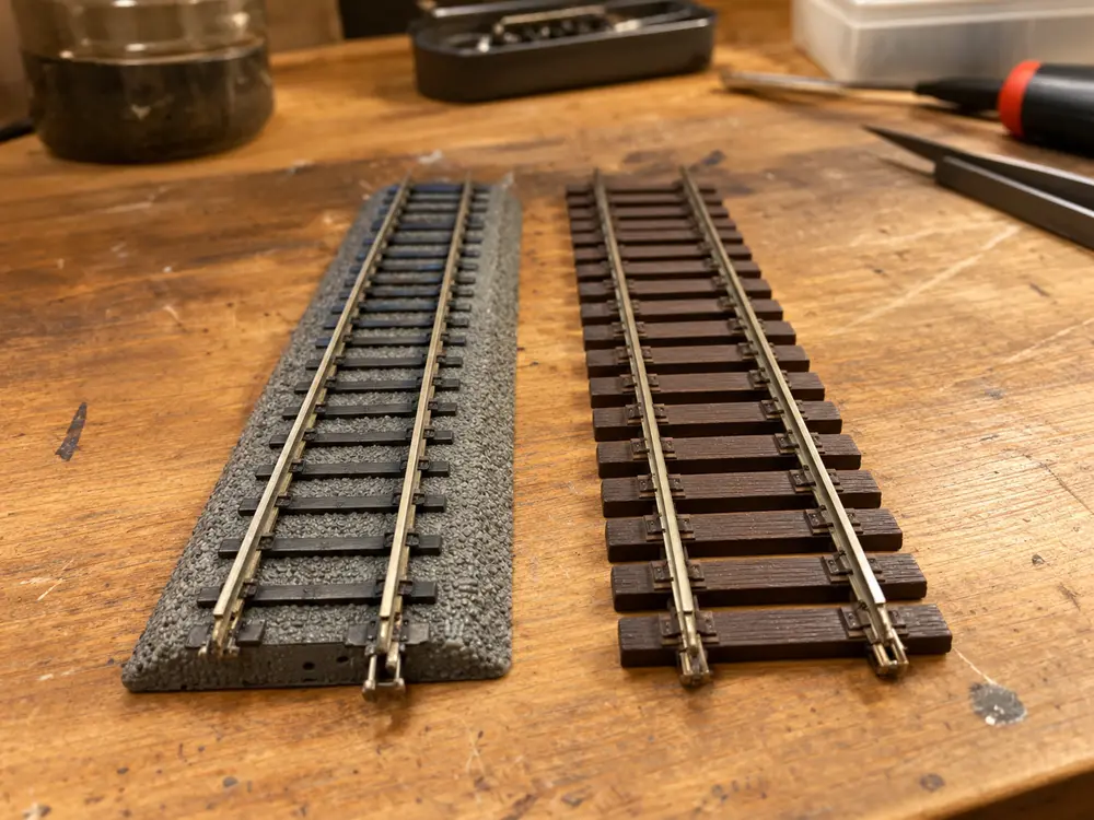 Voie HO à ballast intégré à côté d’une voie classique à traverses apparentes, vue de près